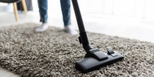 Woman vacuuming carpet at home