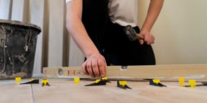 Low-angle view of floor tiling process